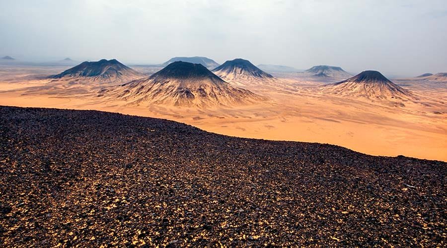 a desert landscape with mountains and sand