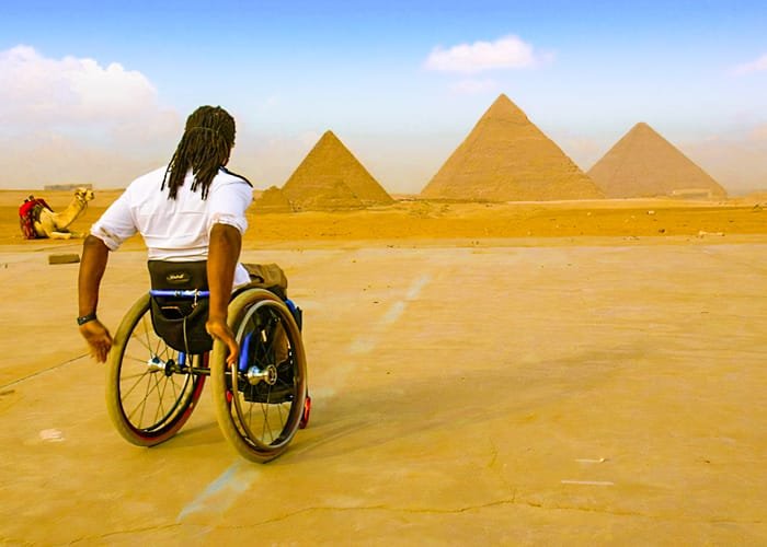 Visitor in a recliner chair with pyramids in the background, guided by Egypt Tour Magic.