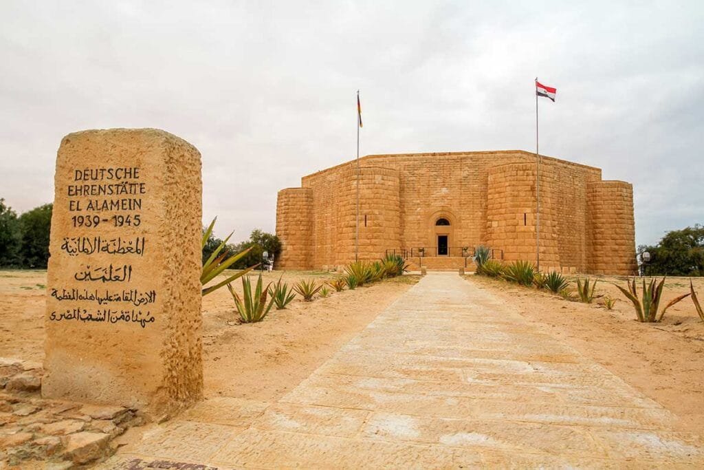 The German War Cemetery in El-Alamein, Egypt, is a solemn site honoring the soldiers who fought and died during World War II, with rows of graves and a peaceful, reflective atmosphere.