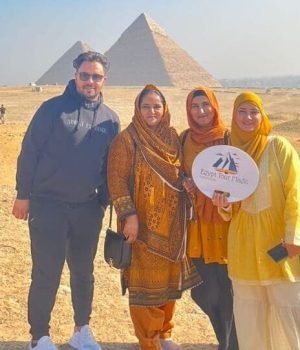a group of people posing for a photo in front of a pyramid