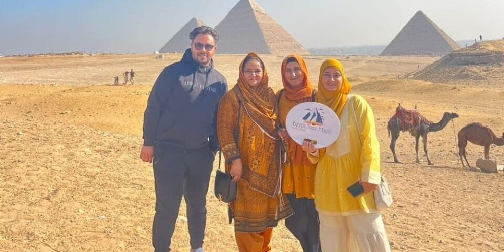 a group of people posing for a photo in front of a pyramid